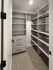 Walk in closet with light carpet