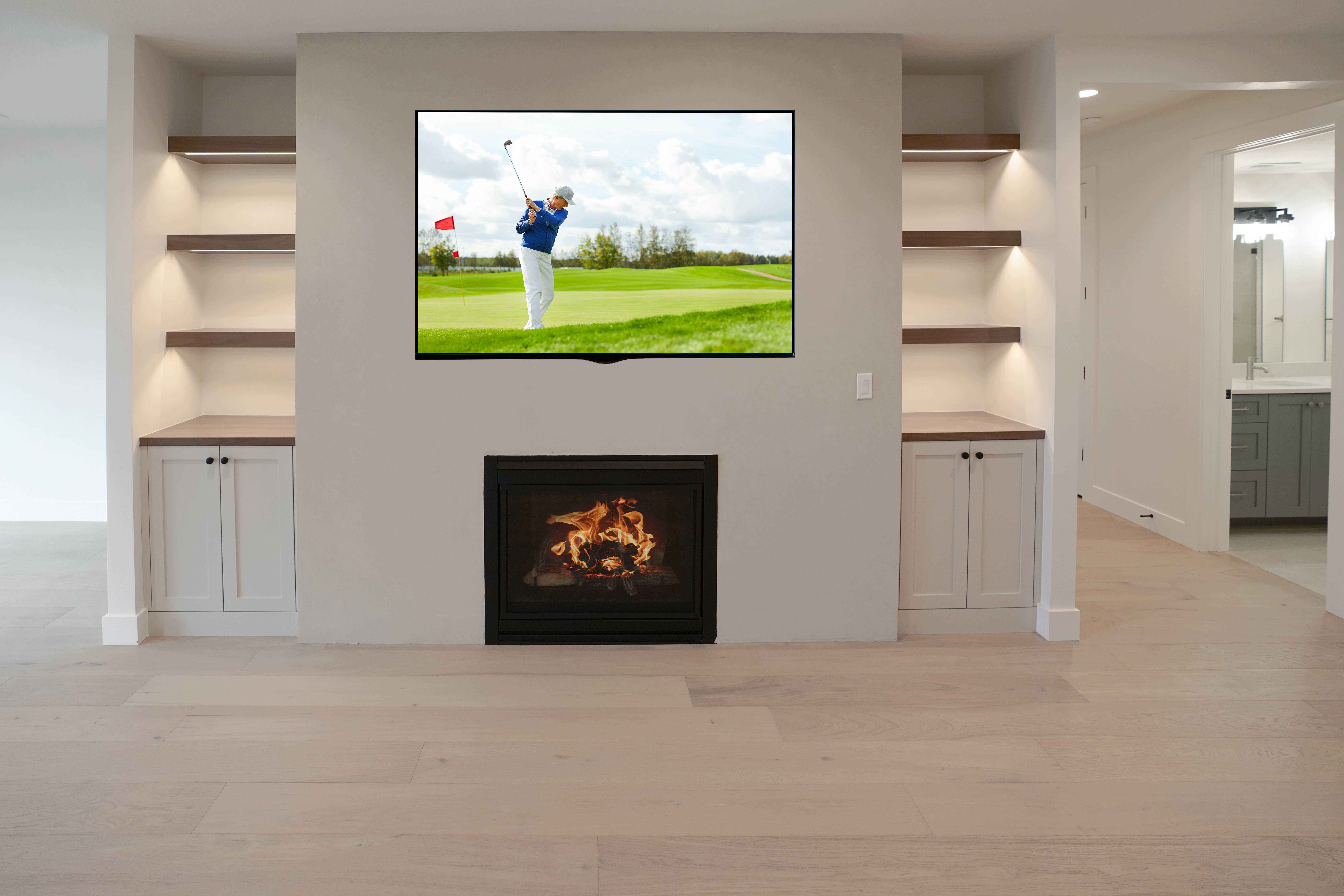 Unfurnished living room with built in shelves, light wood-style floors, and a lit fireplace