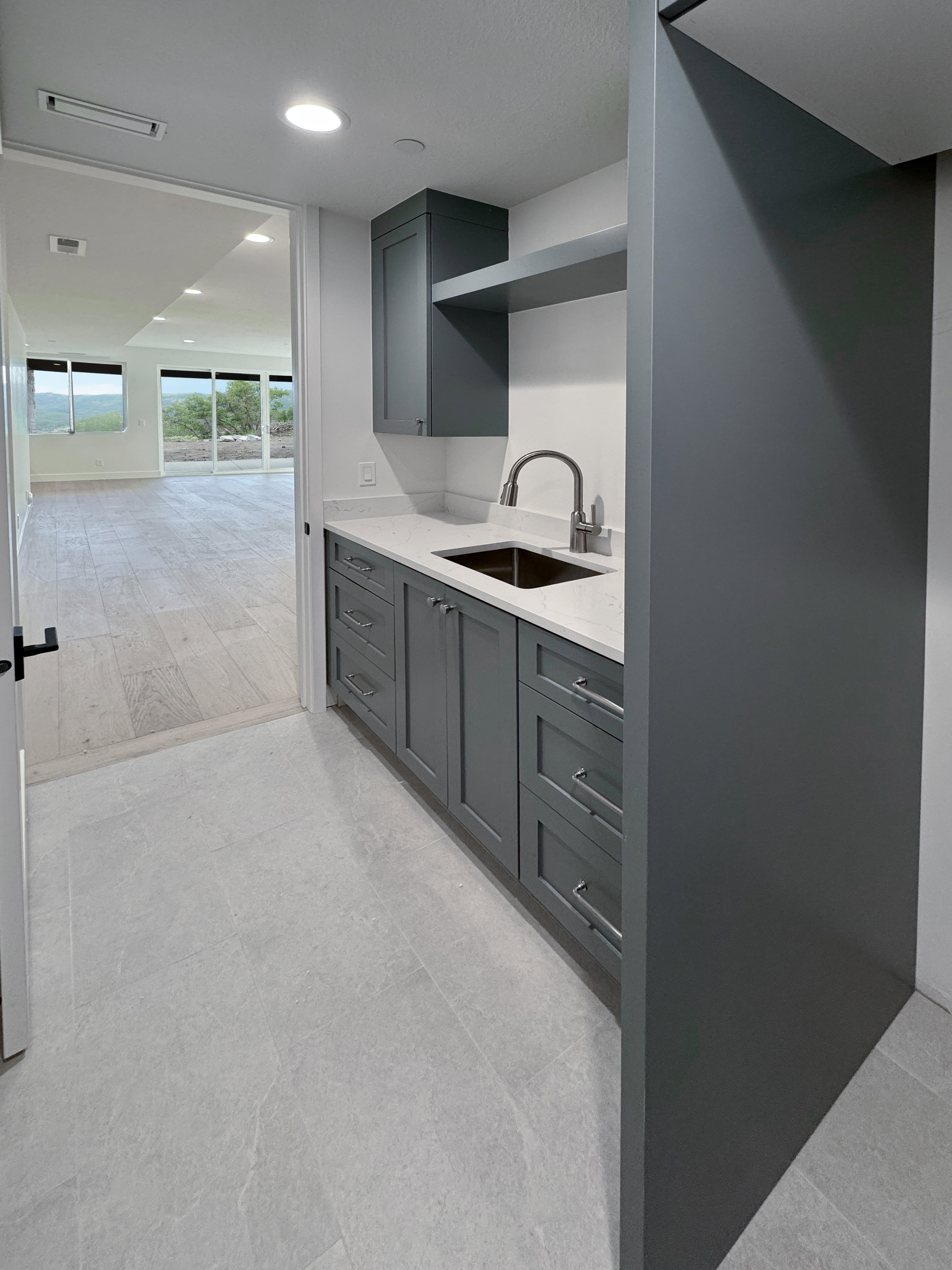 Bar area featuring light stone counters, gray cabinetry, and recessed lighting