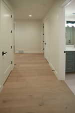 Hallway featuring light wood-type flooring and recessed lighting