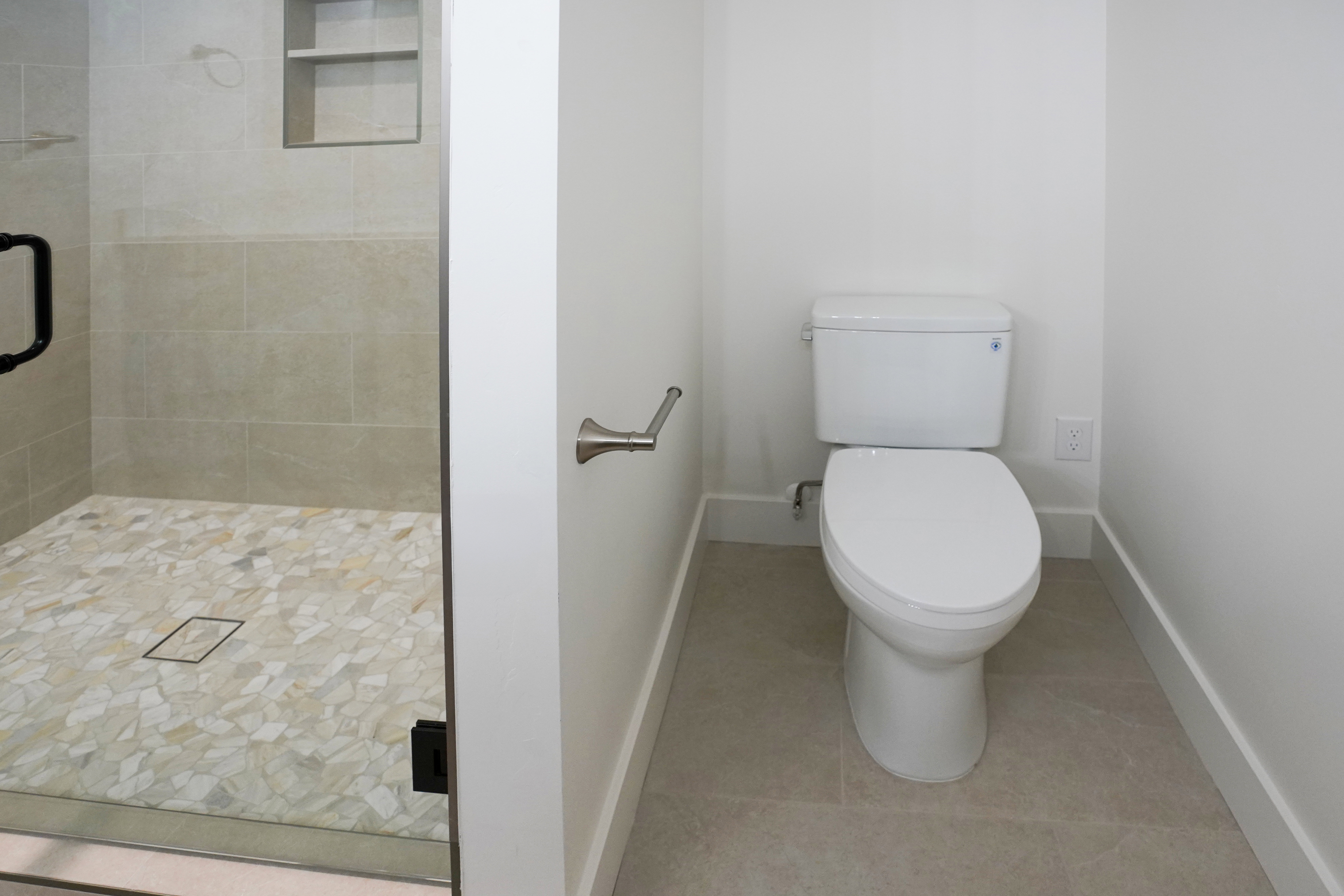 Full bathroom featuring a shower stall and light tile patterned floors