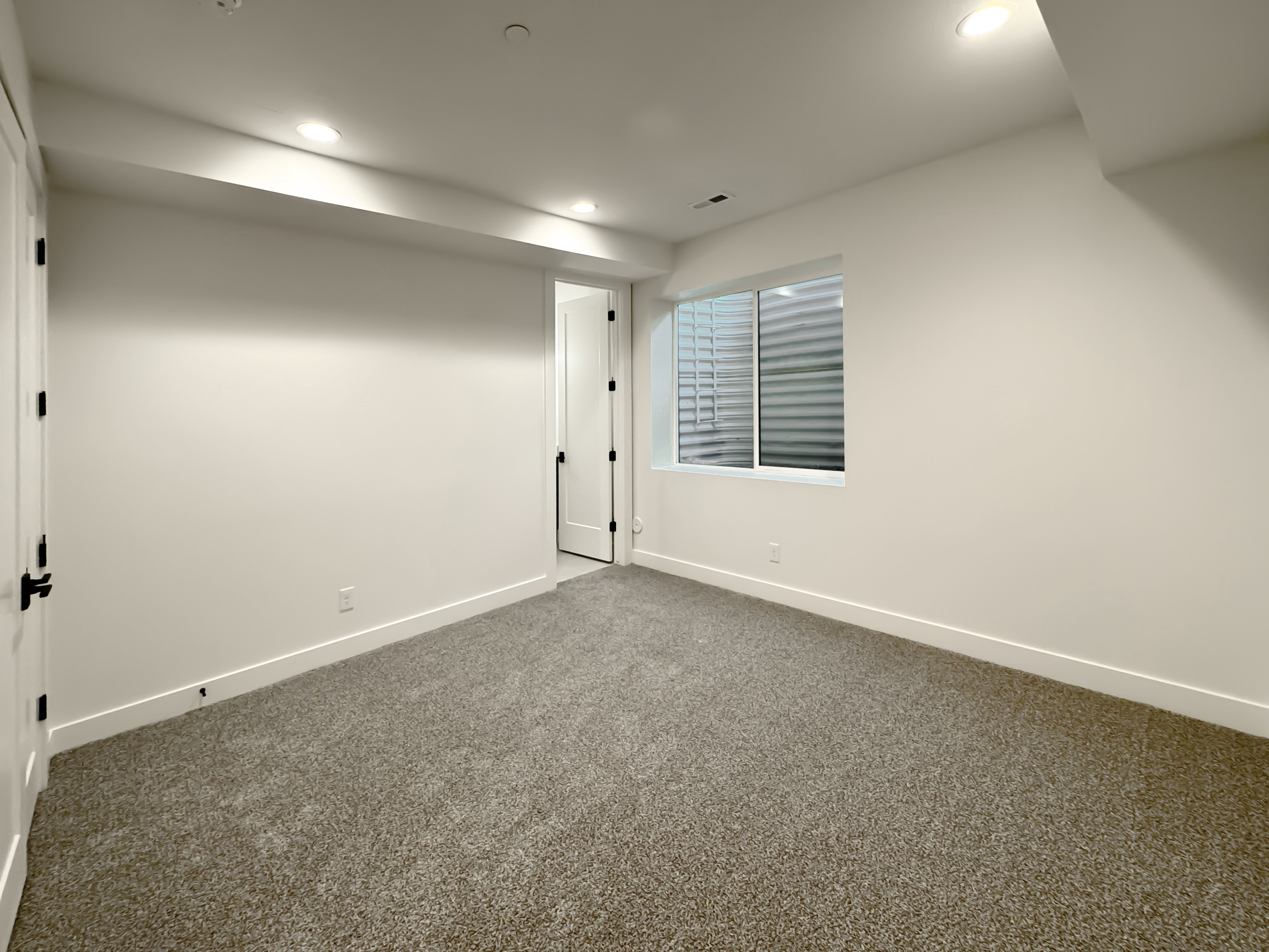 Finished below grade area featuring dark carpet and recessed lighting