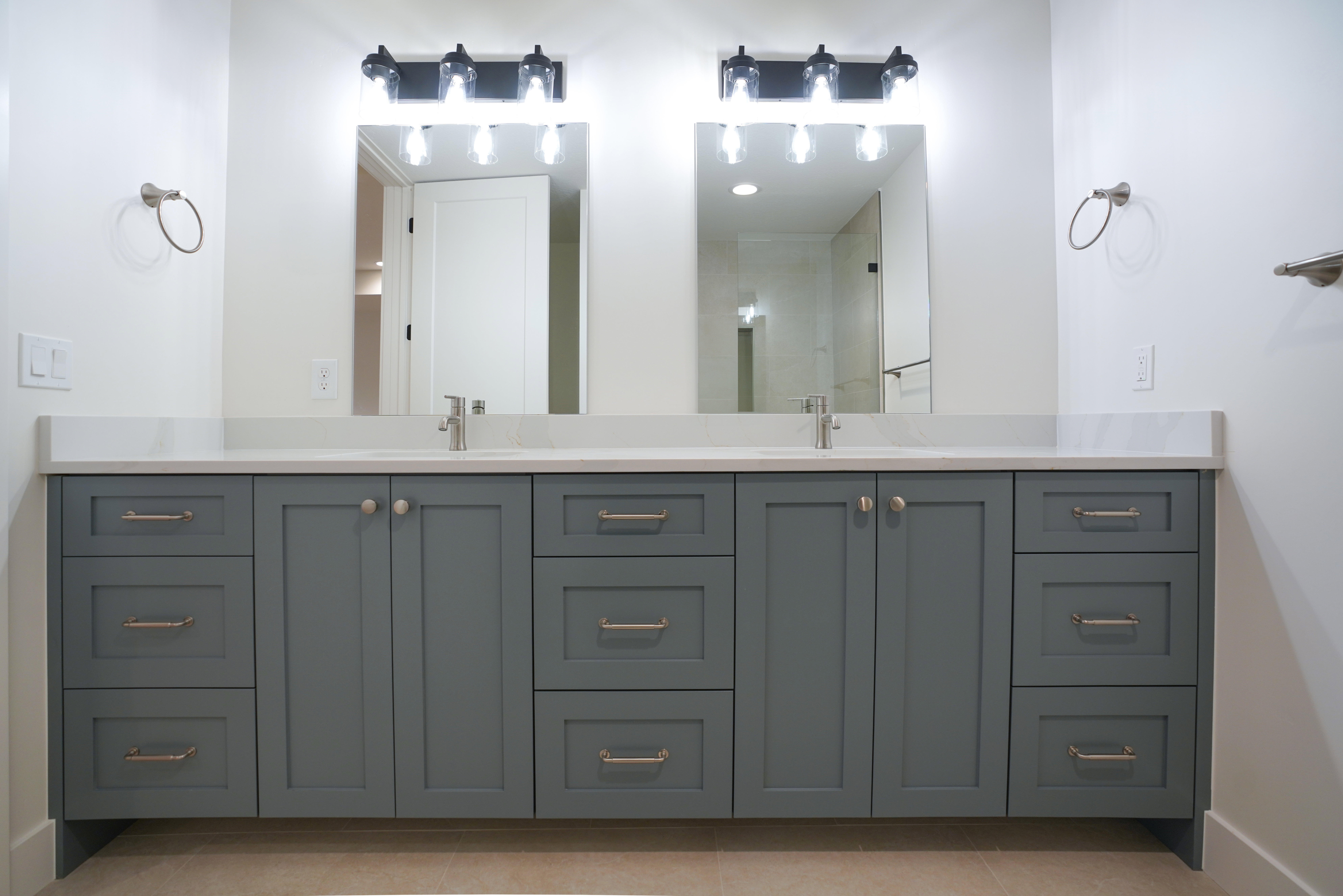 Bathroom featuring double vanity, a shower, and light tile patterned flooring