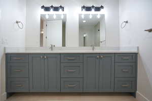 Bathroom featuring double vanity, a shower, and light tile patterned flooring
