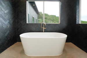 Full bath with a soaking tub and tile walls