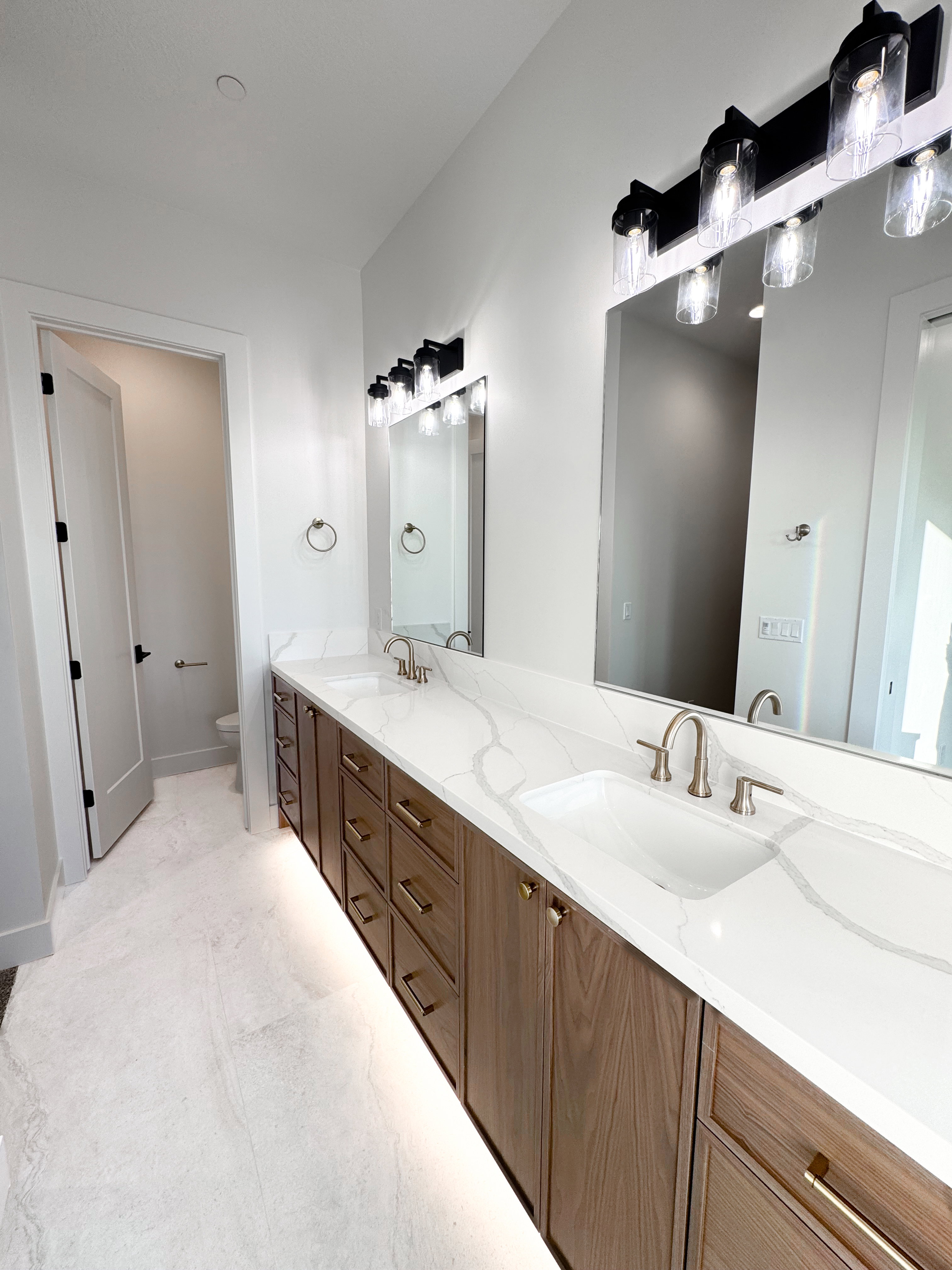 Full bath featuring double vanity and toilet