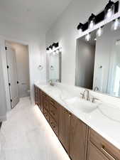 Full bath featuring double vanity and toilet