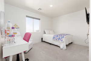 Bedroom with light colored carpet, an office area, and recessed lighting