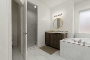 Full bathroom with vanity, light marble finish floors, a stall shower, and a garden tub