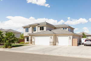 View of front of property with a garage, stucco siding, driveway, and a tile roof
