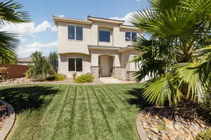 View of front of property featuring stone siding and stucco siding