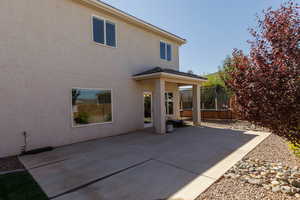 Rear view of house with a patio area, a trampoline, and stucco siding