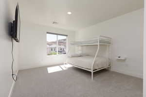 Bedroom with light carpet and recessed lighting