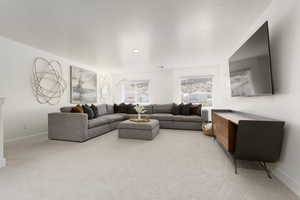 Living area featuring baseboards and light colored carpet