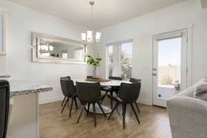 Dining space with light wood finished floors and a chandelier