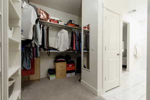 Walk in closet featuring light carpet