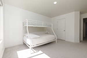 Bedroom featuring light carpet