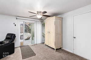 Sitting room with light colored carpet, a ceiling fan, a textured ceiling, and crown molding