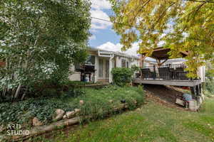 Rear view of house with a deck and a yard