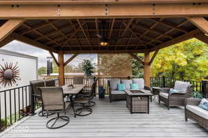 Deck with an outdoor fire pit, a ceiling fan, a gazebo, and outdoor lounge area