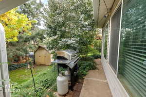 View of grassy yard with a storage unit