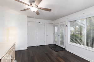 Unfurnished dining area featuring dark wood finished floors and ceiling fan