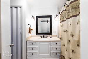 Full bath with vanity and a shower with shower curtain