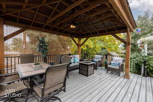 Wooden deck with an outdoor fire pit and an outdoor living / dining area
