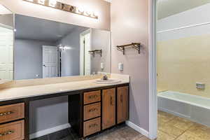 Bathroom featuring vanity, bathing tub / shower combination, and light tile patterned floors