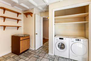 Laundry area with stone finish floors and washer and dryer