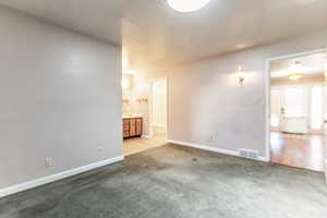 Carpeted spare room with baseboards