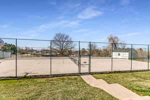 View of tennis court with a gate