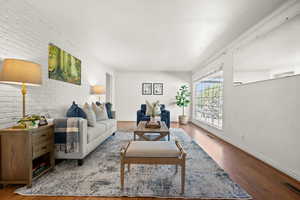 Living area with brick wall and wood finished floors