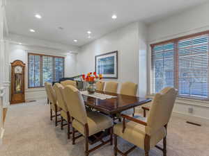 Dining area with light carpet and recessed lighting