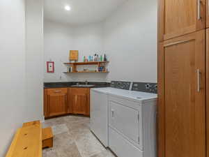 Laundry area with cabinet space, washer and dryer, and recessed lighting