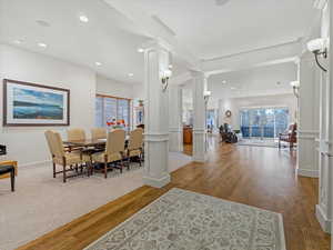 Dining space with ornate columns, wood floors, and recessed lighting