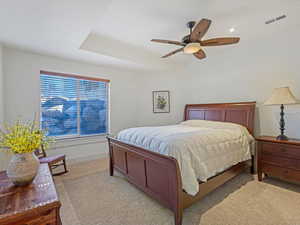 Carpeted bedroom with a ceiling fan and baseboards