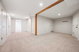 Finished below grade area with light colored carpet and recessed lighting