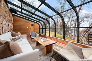 Sunroom featuring wood finished floors and wood walls