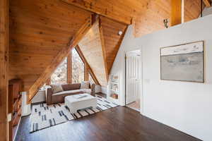 Living area featuring a vaulted wood ceiling and wood-type flooring