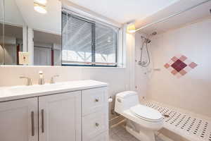 Full bathroom featuring vanity, a shower stall, and light tile patterned flooring