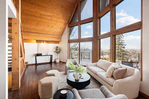 Living area with a vaulted wooden ceiling, wood-type flooring, and healthy amount of natural light