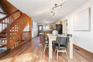 Dining room with light wood-style flooring and stairway