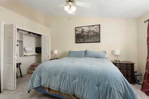 Bedroom featuring light colored carpet, a closet, a ceiling fan, and lofted ceiling