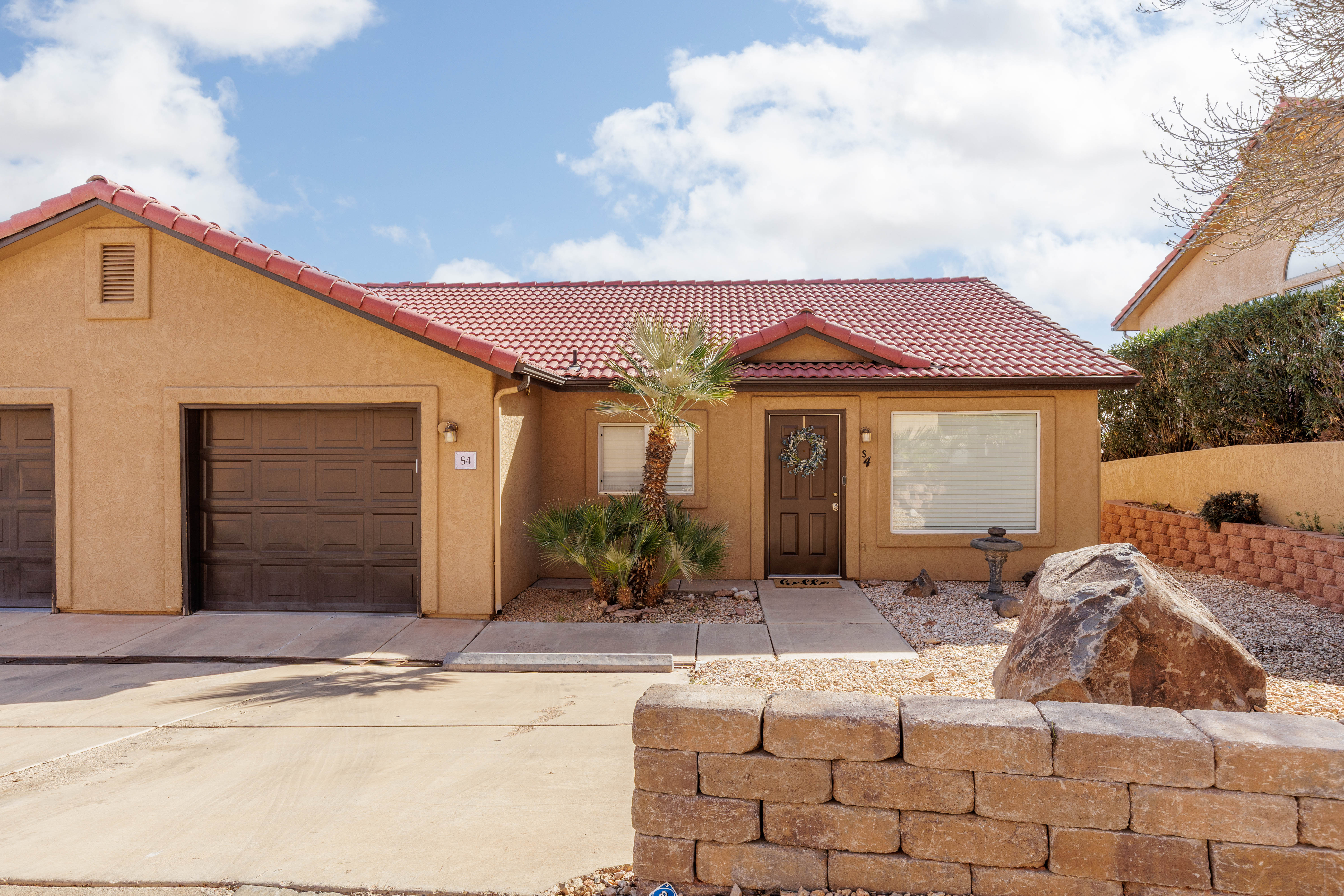Mediterranean / spanish-style house with a garage, a tiled roof, stucco siding, and driveway