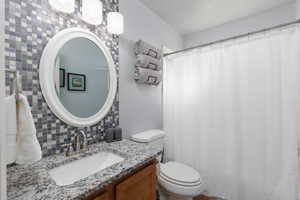 Full bathroom featuring tasteful backsplash, vanity, and a shower with curtain