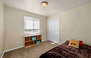 Bedroom featuring light carpet and a closet
