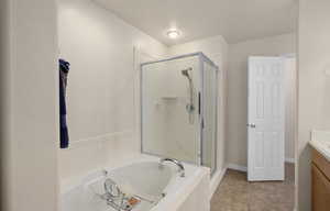 Master Bathroom with vanity, a bath, a stall shower, and light tile patterned floors