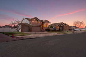Traditional-style home featuring driveway, a residential view, a garage, stucco siding, and stone siding