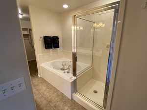 Master bathroom featuring a shower stall, a garden tub, recessed lighting, light tile patterned floors, and a walk in closet
